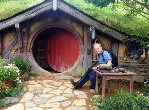 Vor der runden Tür einer Hobbithöhle.